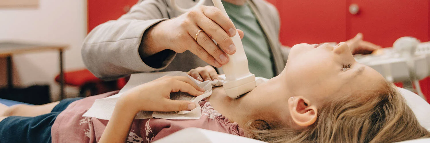 Arzt un tersucht die Schilddrüse eines Patienten mit einem Röntgengerät {{brizy_dc_image_alt imageSrc=